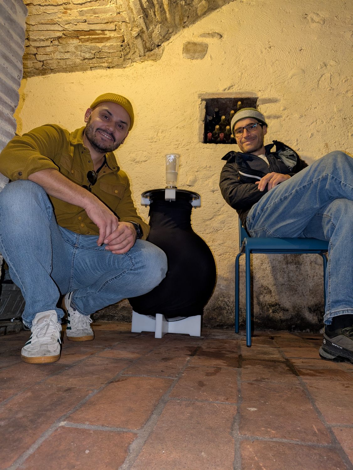 Due persone sedute accanto all'ampolla sigillata, a lavoro finito